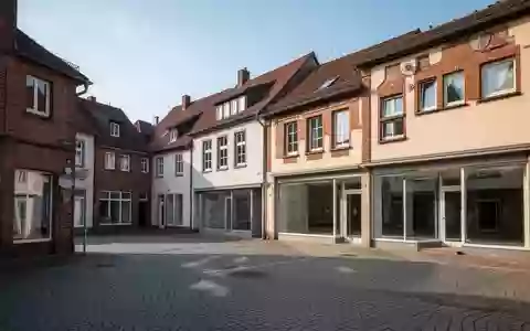 Eine ruhige Straßenkreuzung mit historischer Architektur und leeren Ladenlokalen in einem deutschen Ortskern. - Foto: über boerse-global.de