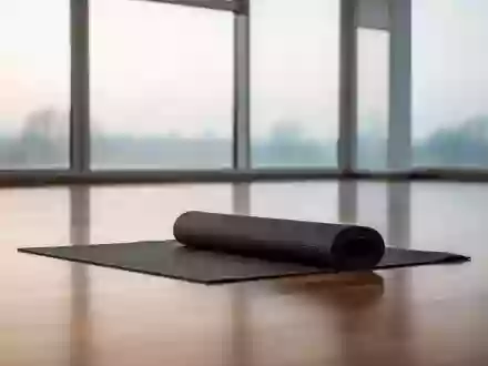 Ein minimalistischer, heller Sportraum mit einer aufgerollten Yogamatte auf einem Parkettboden bei natürlichem Lichteinfall. - Foto: über boerse-global.de