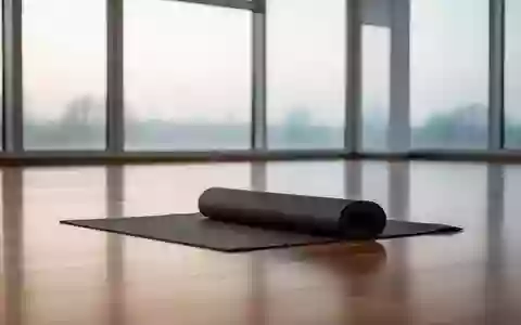 Ein minimalistischer, heller Sportraum mit einer aufgerollten Yogamatte auf einem Parkettboden bei natürlichem Lichteinfall. - Foto: über boerse-global.de