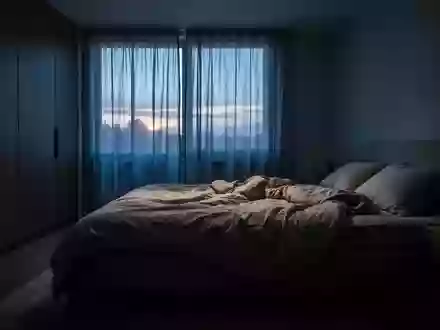 Ein ungemachtes Bett in einem ruhig beleuchteten Schlafzimmer während der Morgendämmerung. - Foto: über boerse-global.de