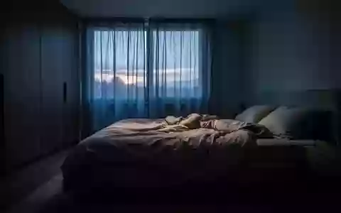 Ein ungemachtes Bett in einem ruhig beleuchteten Schlafzimmer während der Morgendämmerung. - Foto: über boerse-global.de