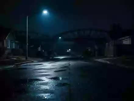 Eine menschenleere, schwach beleuchtete Straße bei Nacht in der Nähe einer Brücke. - Foto: über boerse-global.de