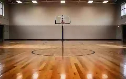 Ein leerer Basketballplatz mit glänzendem Holzboden und einem Korb in einer minimalistischen, hellen Halle. - Foto: über boerse-global.de