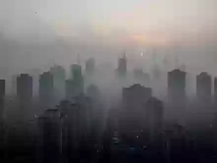 Dichte, graue Smog-Atmosphäre über einer städtischen Skyline, die die Auswirkungen von Luftverschmutzung verdeutlicht. - Foto: über boerse-global.de