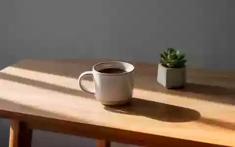 Ein minimalistischer, aufgeräumter Schreibtisch mit einer Kaffeetasse und einer kleinen Pflanze in natürlichem Licht. - Foto: über boerse-global.de