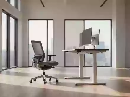 Ein heller, minimalistischer Büroarbeitsplatz mit einem höhenverstellbaren Schreibtisch in Stehposition und einem leeren Bürostuhl. - Foto: über boerse-global.de