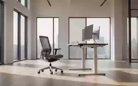 Ein heller, minimalistischer Büroarbeitsplatz mit einem höhenverstellbaren Schreibtisch in Stehposition und einem leeren Bürostuhl. - Foto: über boerse-global.de