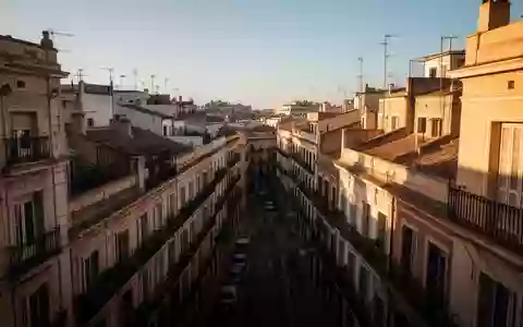 Dichte stĂ€dtische Wohnbebauung in einer spanischen Stadt mit klassischen ApartmenthĂ€usern bei Sonnenlicht. - Foto: ĂŒber boerse-global.de