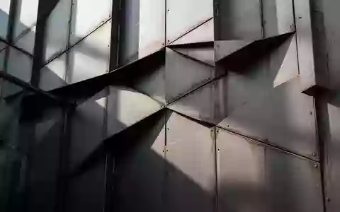 Moderne, minimalistische Gebäudefassade mit geometrischen Stahlpaneelen bei Tageslicht. - Foto: über boerse-global.de