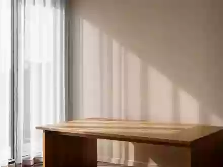 Ein minimalistischer, sonnendurchfluteter Arbeitsplatz mit einem leeren Schreibtisch in einem ruhigen Raum. - Foto: über boerse-global.de