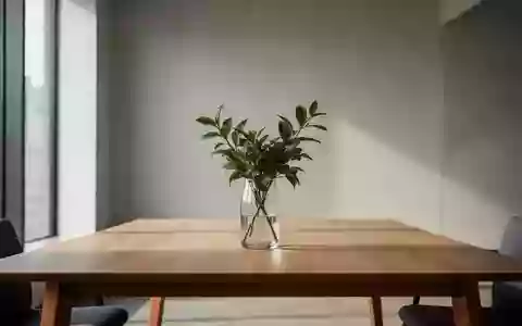 Ein minimalistischer, heller Büroarbeitsplatz mit einem leeren Holztisch und einer Pflanze vor einer neutralen Wand. - Foto: über boerse-global.de