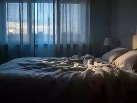 Ein ungemachtes Bett in einem ruhig beleuchteten Schlafzimmer im sanften Licht der Morgendämmerung. - Foto: über boerse-global.de