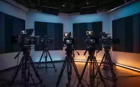 Ein modernes, minimalistisches Fernsehstudio mit professioneller Aufnahmetechnik in einer abendlichen, atmosphärischen Beleuchtung. - Foto: über boerse-global.de
