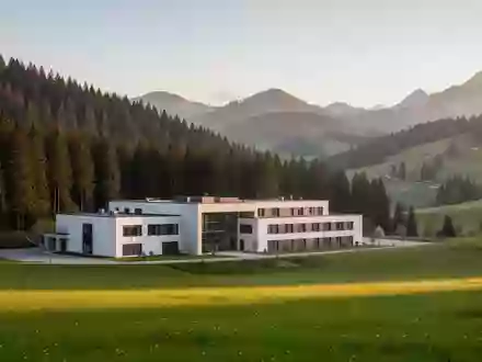 Modernes Reha-Zentrum in einer ruhigen Berglandschaft der Steiermark bei Sonnenuntergang. - Foto: über boerse-global.de
