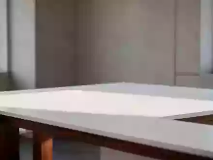Ein minimalistischer Arbeitsplatz mit einem leeren Holztisch und natĂĽrlichem Lichteinfall in einer modernen, neutralen Umgebung. - Foto: ĂĽber boerse-global.de