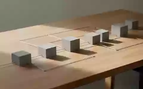 Ein minimalistischer Schreibtisch mit geometrischen Objekten und Verbindungslinien zur Visualisierung von Projektstrukturen. - Foto: ĂĽber boerse-global.de