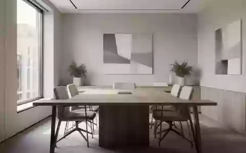 Ein minimalistisch gestalteter Besprechungsraum mit zwei leeren Stühlen an einem Holztisch bei Tageslicht. - Foto: über boerse-global.de