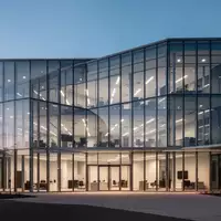 Moderne Büroarchitektur mit Glasfassade bei Dämmerung, symbolisiert betriebliche Investitionen und Unternehmensverwaltung. - Foto: über boerse-global.de