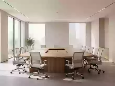 Heller, moderner Konferenzraum mit kreisförmig angeordneten Stühlen und Holztisch in einer minimalistischen Büroumgebung. - Foto: über boerse-global.de
