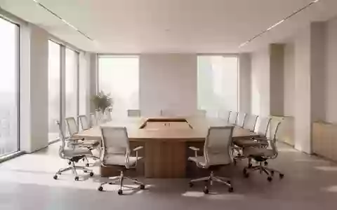 Heller, moderner Konferenzraum mit kreisförmig angeordneten Stühlen und Holztisch in einer minimalistischen Büroumgebung. - Foto: über boerse-global.de