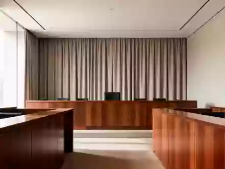Ein leerer, minimalistisch gestalteter Gerichtssaal mit klaren architektonischen Linien und weichem Tageslicht. - Foto: über boerse-global.de