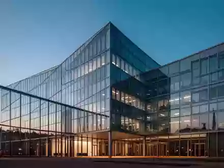 Ein modernes Bürogebäude aus Glas und Stahl in Frankfurt bei Dämmerung, das die architektonischen Linien betont. - Foto: über boerse-global.de