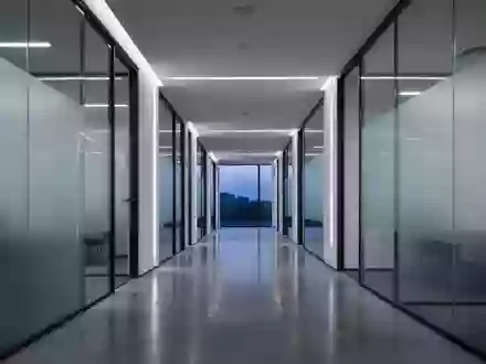 Ein minimalistischer, moderner BĂĽroflur mit kĂĽhler Beleuchtung und klaren architektonischen Linien ohne sichtbare Technologie. - Foto: ĂĽber boerse-global.de