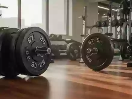 Ein minimalistischer Fitnessraum mit Hantelscheiben auf einem Holzboden in hellem, natürlichem Licht. - Foto: über boerse-global.de