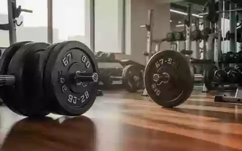 Ein minimalistischer Fitnessraum mit Hantelscheiben auf einem Holzboden in hellem, natürlichem Licht. - Foto: über boerse-global.de