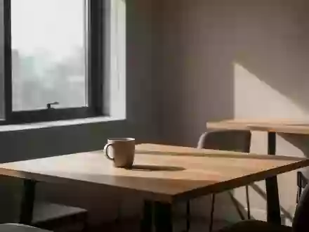 Ein leerer Pausenraum mit einem einzelnen Kaffeebecher auf einem Holztisch bei natürlichem Licht. - Foto: über boerse-global.de