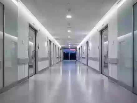 Ein moderner, menschenleerer Krankenhausflur in neutralem Licht mit poliertem Boden und minimalistischer Architektur. - Foto: über boerse-global.de