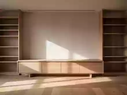 Ein minimalistisch eingerichteter, aufgeräumter Wohnbereich mit einer leeren Holzkommode in hellem Tageslicht. - Foto: über boerse-global.de