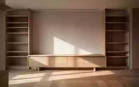Ein minimalistisch eingerichteter, aufgeräumter Wohnbereich mit einer leeren Holzkommode in hellem Tageslicht. - Foto: über boerse-global.de