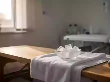 Ein minimalistischer Behandlungsraum mit einer Holzbank und einer Schale mit EiswĂĽrfeln auf einem weiĂźen Handtuch. - Foto: ĂĽber boerse-global.de