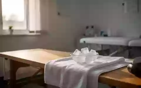 Ein minimalistischer Behandlungsraum mit einer Holzbank und einer Schale mit Eiswürfeln auf einem weißen Handtuch. - Foto: über boerse-global.de