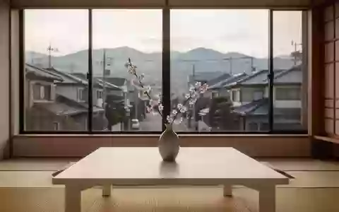 Ein minimalistischer japanischer Wohnraum mit Kirschblütenzweig in einer Vase auf einem Holztisch vor einem Fenster. - Foto: über boerse-global.de