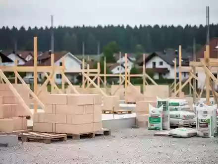 Baustelle für ein kommunales Wohnungsbauprojekt mit Baumaterialien vor einem Wohngebiet in einer bayerischen Kleinstadt. - Foto: über boerse-global.de