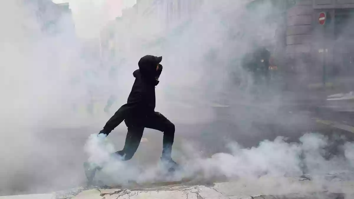 Ein Demonstrant wirft in Rennes eine Tränengasgranate in Richtung der Polizei. - Bild: Jeremias Gonzalez/AP/dpa