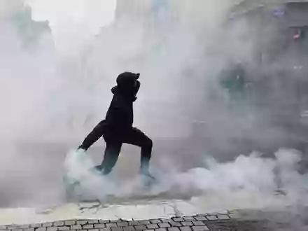 Ein Demonstrant wirft in Rennes eine Tränengasgranate in Richtung der Polizei. - Foto: Jeremias Gonzalez/AP/dpa