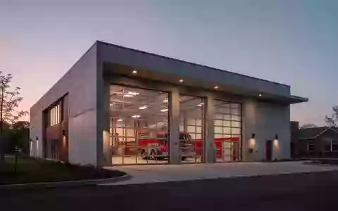 Modernes Feuerwehrgebäude in der Dämmerung mit minimalistischer Betonarchitektur und Glasfronten - Foto: über boerse-global.de