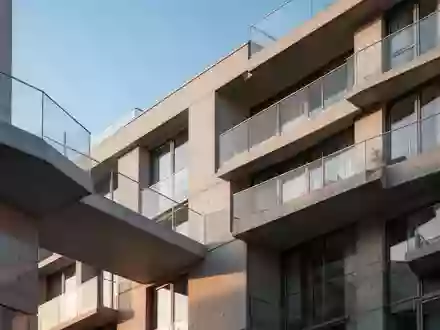 Architektonisches Detail einer modernen Wohnhausfassade in Berlin bei klarem Himmel. - Foto: über boerse-global.de