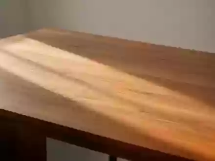 Eine leere, minimalistische Schreibtischoberfläche aus Holz mit weichem, natürlichem Lichteinfall und Schattenwurf. - Foto: über boerse-global.de