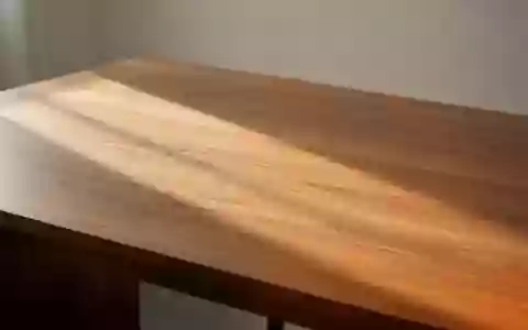 Eine leere, minimalistische Schreibtischoberfläche aus Holz mit weichem, natürlichem Lichteinfall und Schattenwurf. - Foto: über boerse-global.de