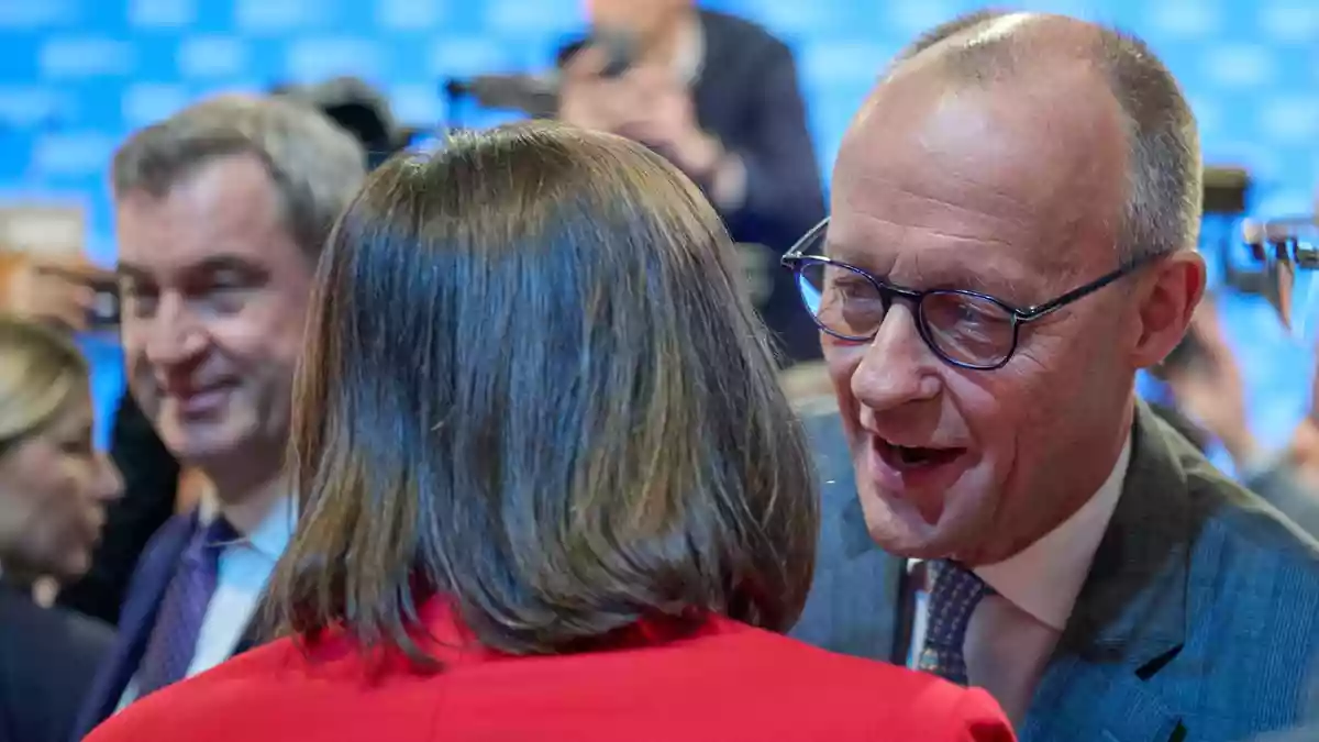 Friedrich Merz begrüßt Ilse Aigner mit Wangenküsschen. - Bild: Peter Kneffel/dpa