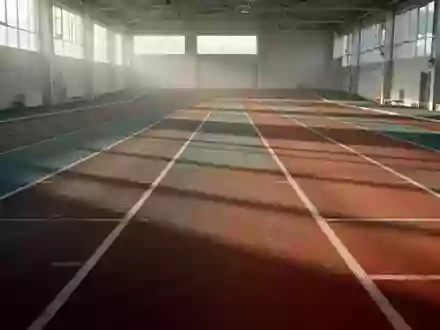 Leere, hell beleuchtete Leichtathletikbahn in einer Sporthalle mit klaren Linien und natürlichem Lichteinfall. - Foto: über boerse-global.de