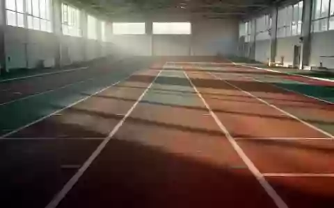 Leere, hell beleuchtete Leichtathletikbahn in einer Sporthalle mit klaren Linien und natürlichem Lichteinfall. - Foto: über boerse-global.de