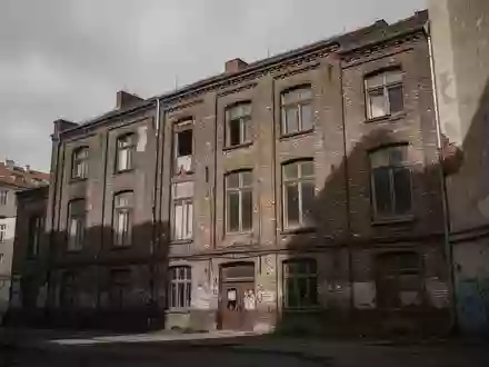 Fassade eines alten Backsteingebäudes in Berlin unter einem bewölkten Himmel, das leer und verlassen wirkt. - Foto: über boerse-global.de