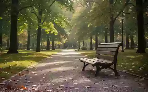 Ein sonniger Parkweg mit einer leeren Holzbank, umgeben von Bäumen, als Symbol für körperliche Aktivität im Alter. - Foto: über boerse-global.de