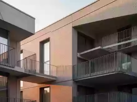 Moderne Wohnhausfassade mit klaren architektonischen Linien und leeren Balkonen bei Tageslicht. - Foto: über boerse-global.de