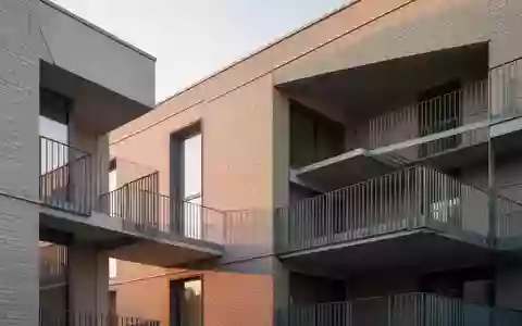 Moderne Wohnhausfassade mit klaren architektonischen Linien und leeren Balkonen bei Tageslicht. - Foto: über boerse-global.de